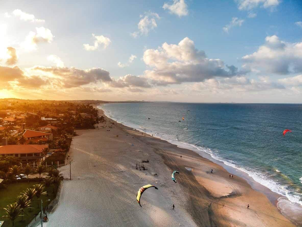 Pôr do sol na Praia do Cumbuco com velas de kitesurf